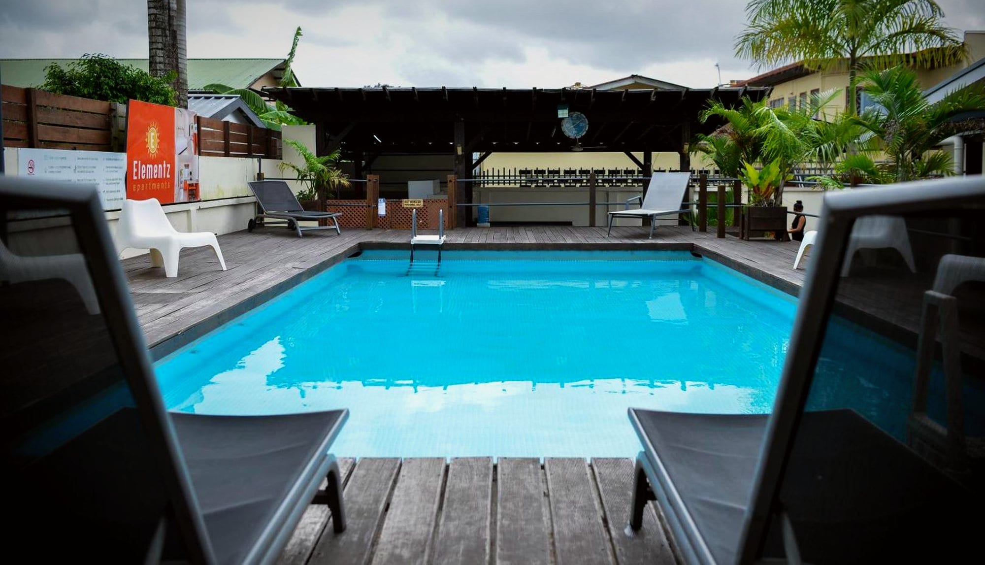The pool deck and palms at Elementz Apartments in Paramaribo