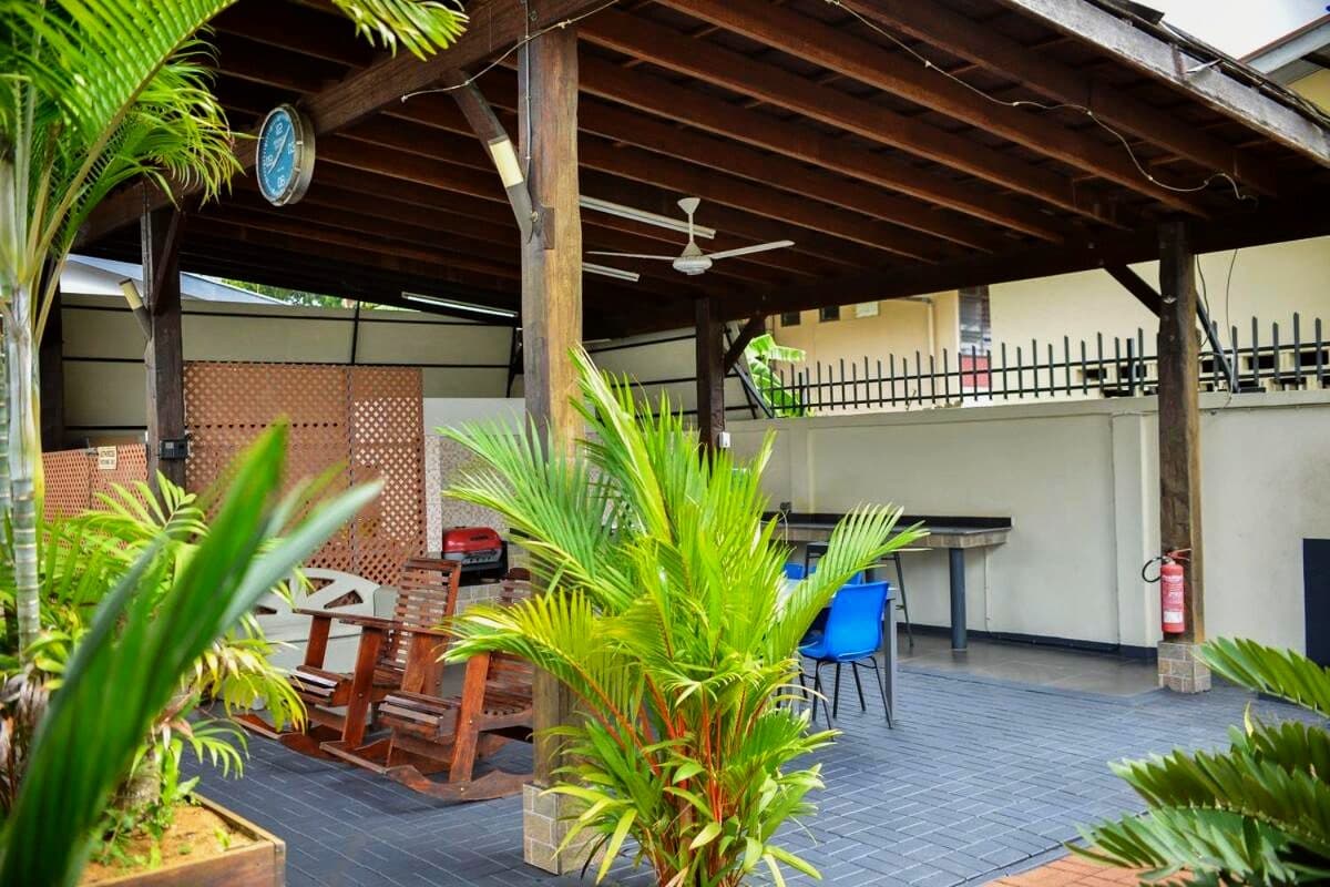Timber pergola and palms beside the pool at Elementz Apartments
